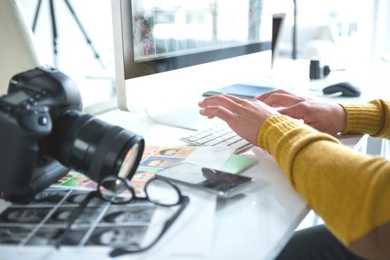 photographer editing photos on a laptop, How to make $100,000year investing in real estate in Portland Oregon